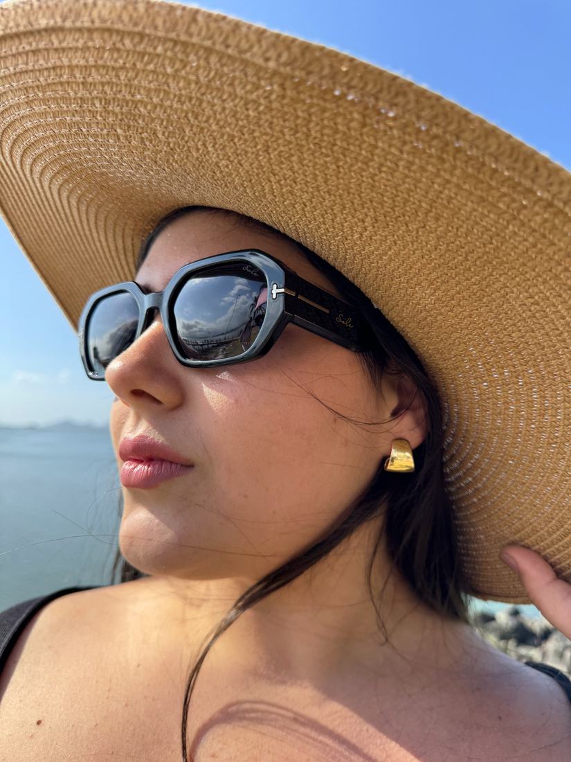 Mulher usando óculos de sol Sole Occhiali com chapéu de palha