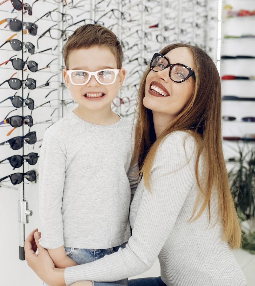 Mãe e filho experimentando armações de óculos Sole Occhiali em ótica parceira