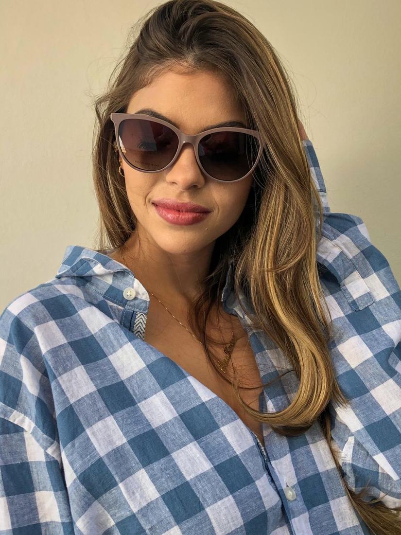 Mulher usando óculos de sol Sole Occhiali com camisa xadrez