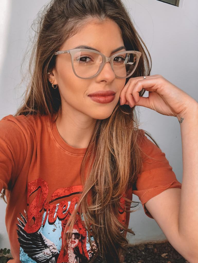 Mulher usando armação de óculos Sole Occhiali com camiseta laranja